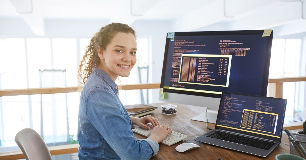 Girl web developer on front of laptop and iMac